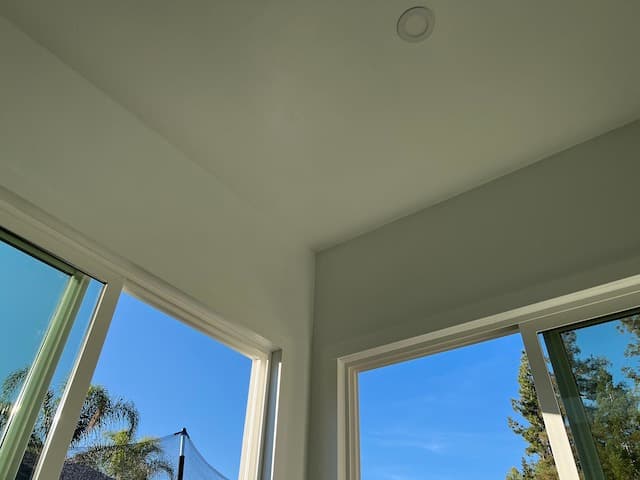 Backyard office interior corner with recessed lighting and floor-to-ceiling windows