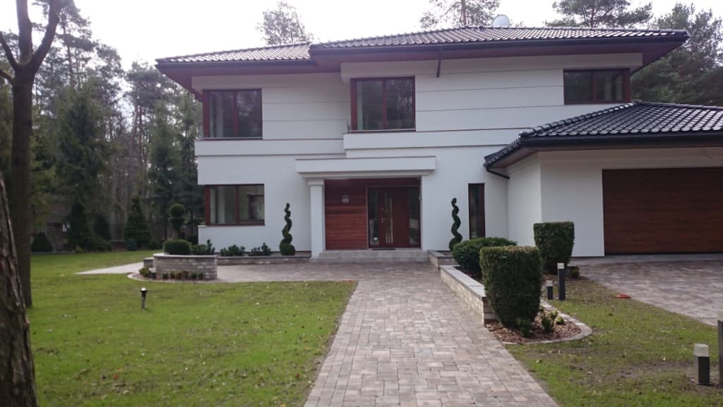 Casa moderna de bajo consumo con grandes ventanas y puerta de garaje de madera