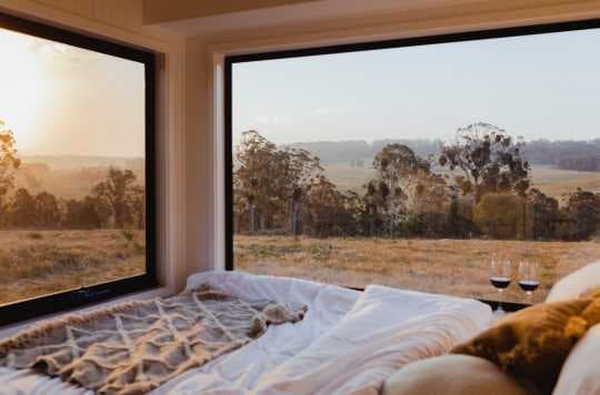 large windows by the bed in a tiny house