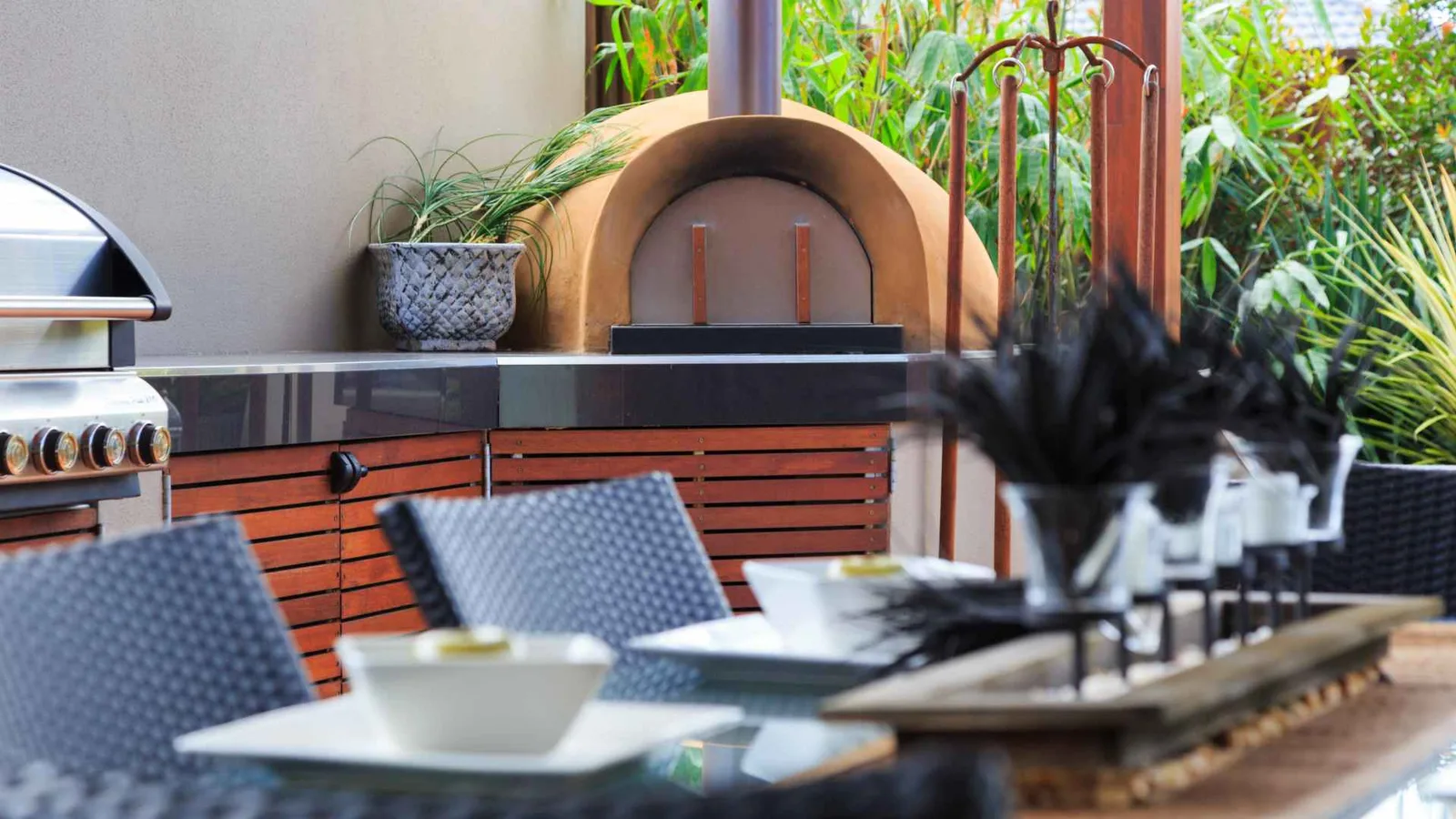 Outdoor kitchen with pizza oven and dining area