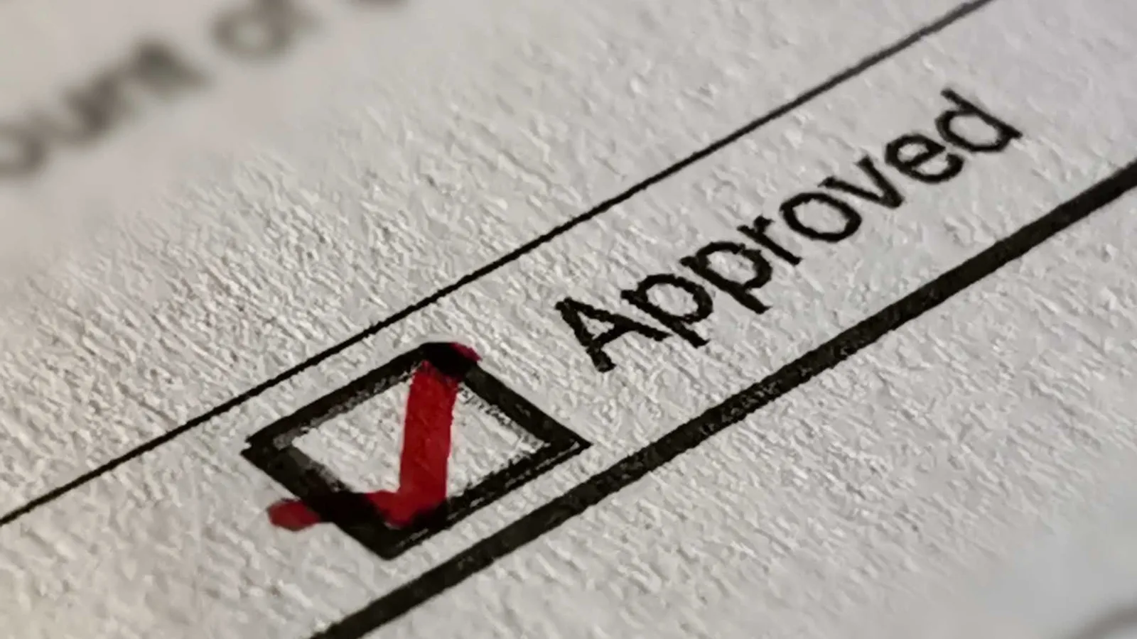 Ilustración de un plano de ADU preaprobado: la palabra "approved" con una marca de verificación verde
