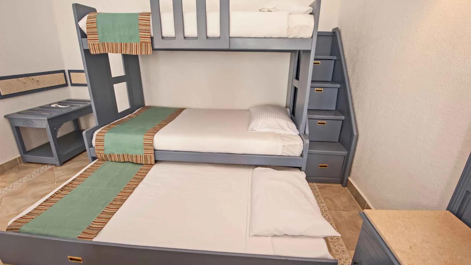 Literas de tres niveles apiladas en un dormitorio compacto