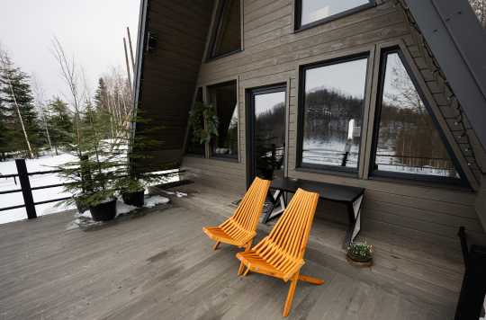 Dark siding and black-frame windows of a tiny home